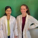 Zwei Schülerrinnen stehen vor einer Tafel