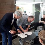 Der schulleiter beugt sich in der gruppe über ein formulars