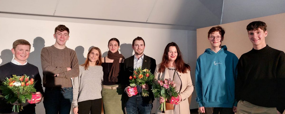 Schüler überreichen Blumensträuße