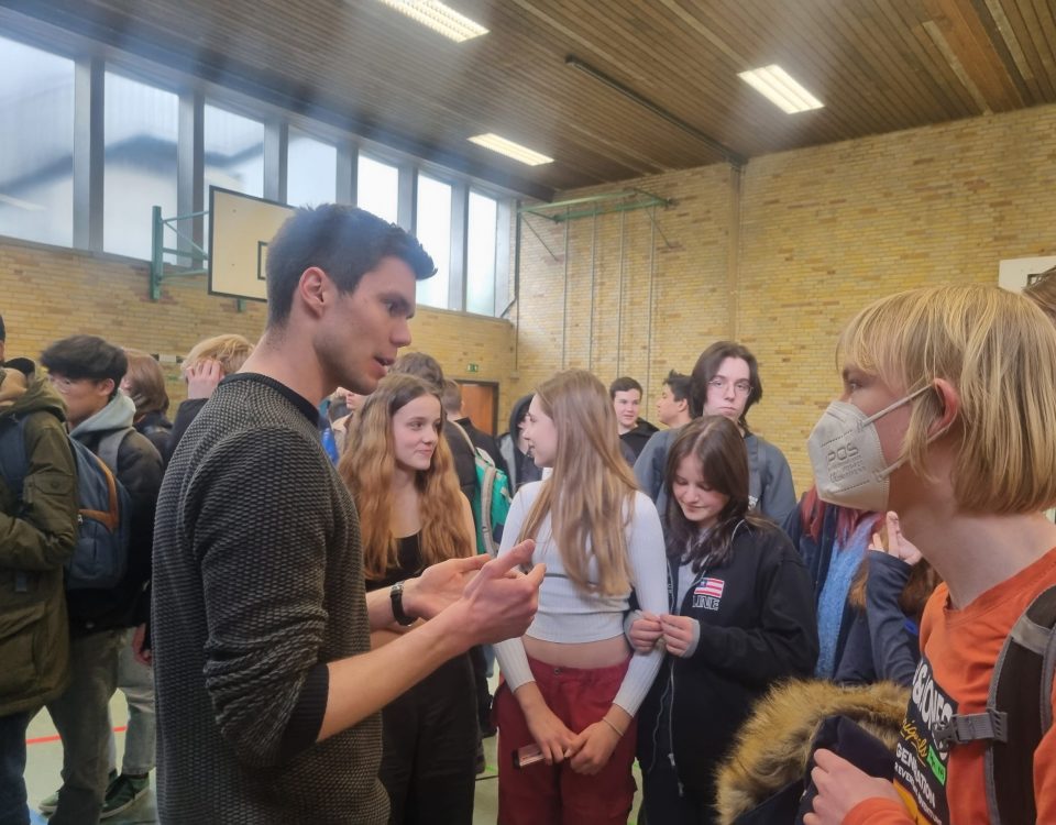 mehrere Schüler unterhalten sich in einer Turnhalle