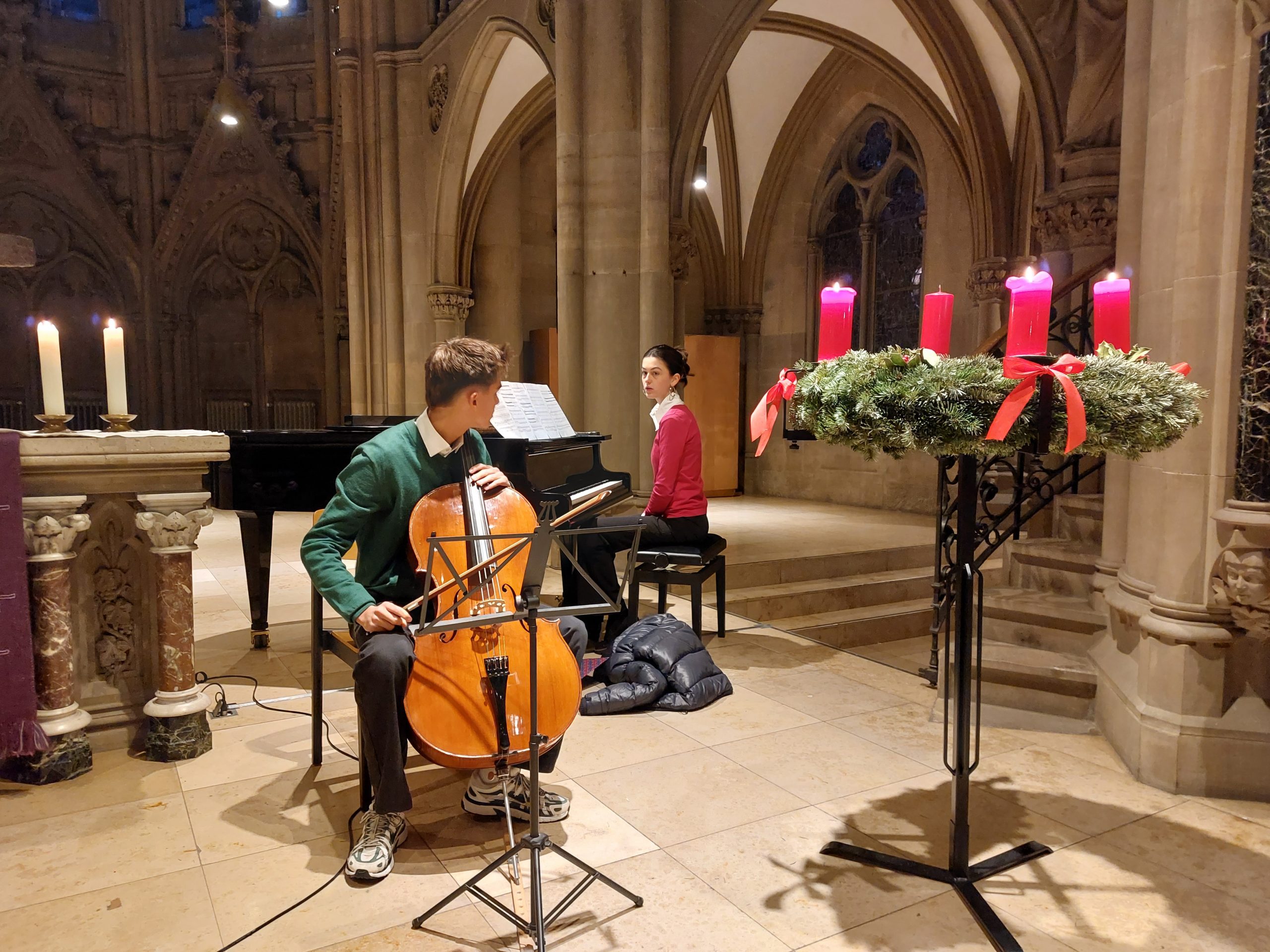 Zwei Personen spielen ein Klavier und ein Cello in einer Kirche.