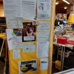 Man sieht eine Plakatwand mit Beschreibungen der Vesperkirche