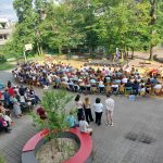 Blick von oben auf Schulhof auf welchem Abi ausgabe stadfindet, Herr Wolnitz spricht auf Schulhof