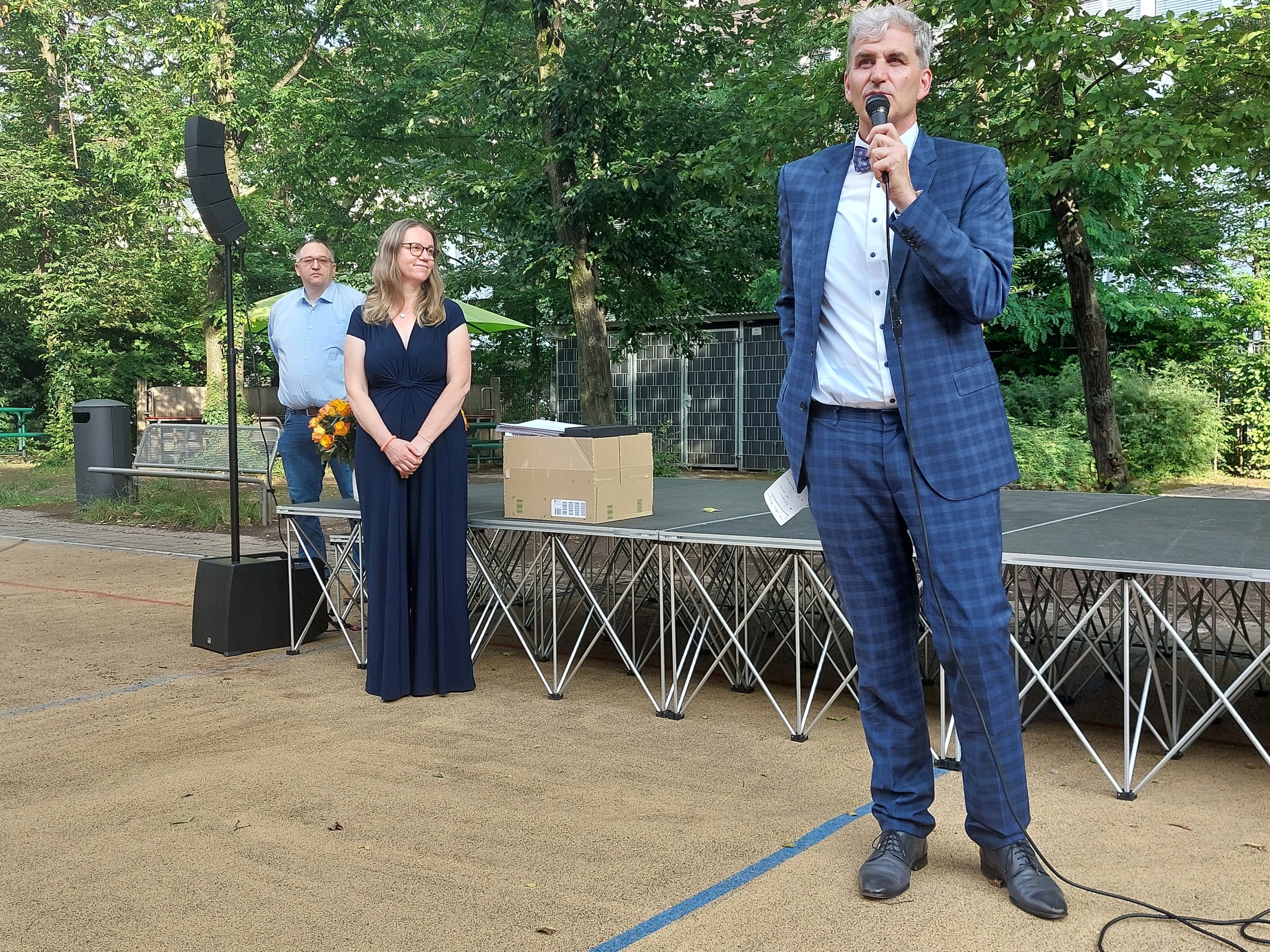 Herr Wollnitz steht vor dem Podium und hält eine Rede