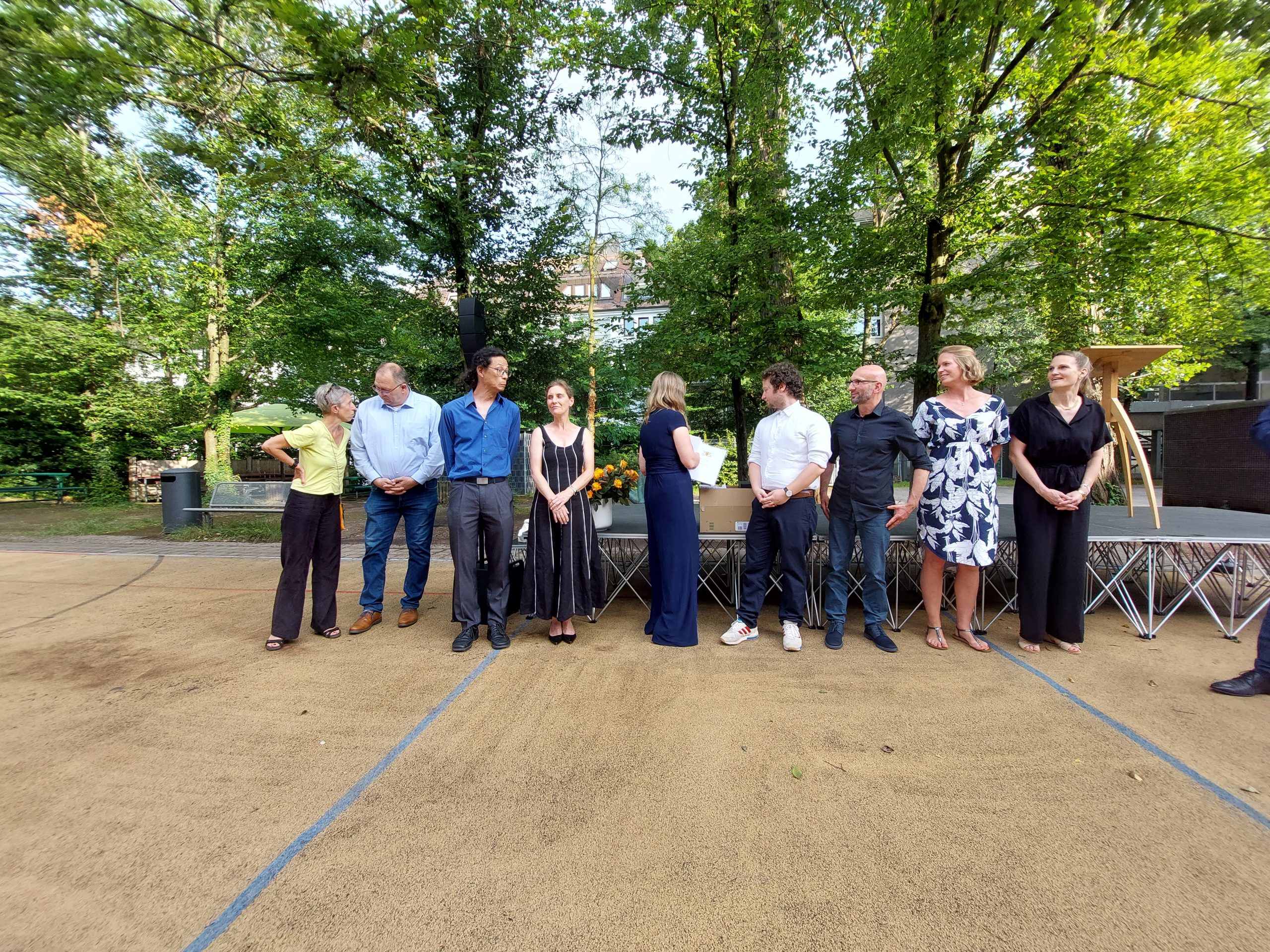 Die Tutor*innen der Abiturienten stehen in einer Reihe vor dem Podium mit den Zeugnissen